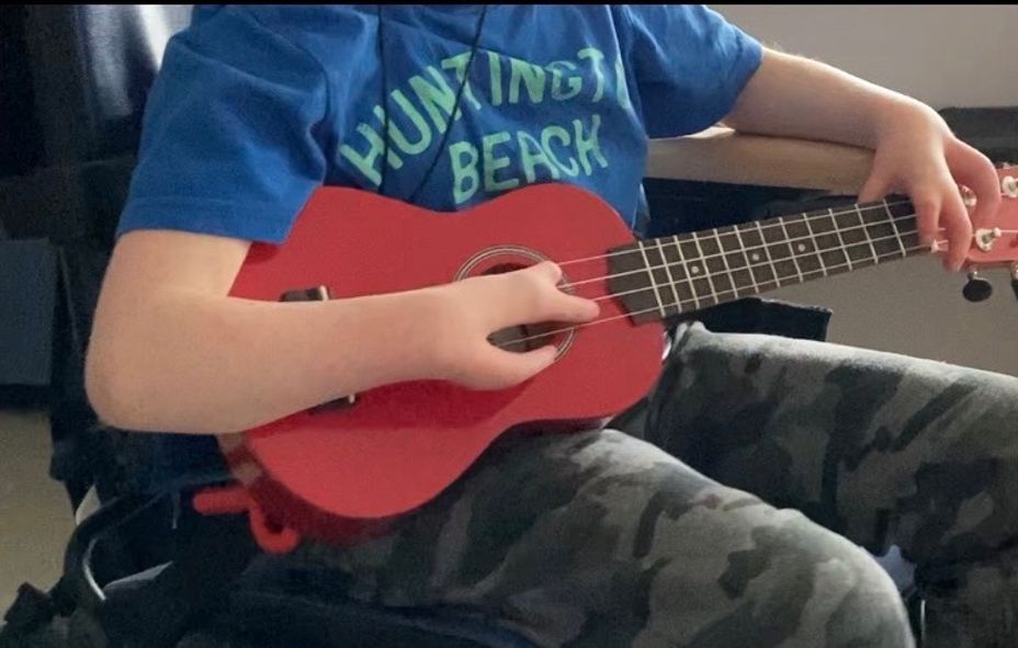 <p>Any suggestions on how to adapt a ukulele for this guy to hold/play?</p>